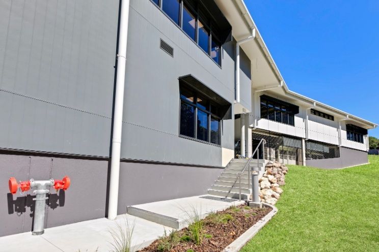 A Large Building With Stairs and a Fire Hydrant on the Side of It — Architectural Glass Solutions QLD in Cooroy, QLD
