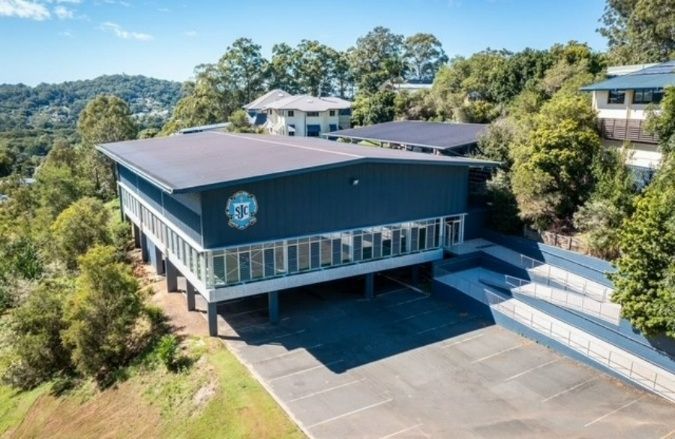 An Aerial View of a Large Building on Top of a Hill Surrounded by Trees — Architectural Glass Solutions QLD in Cooroy, QLD