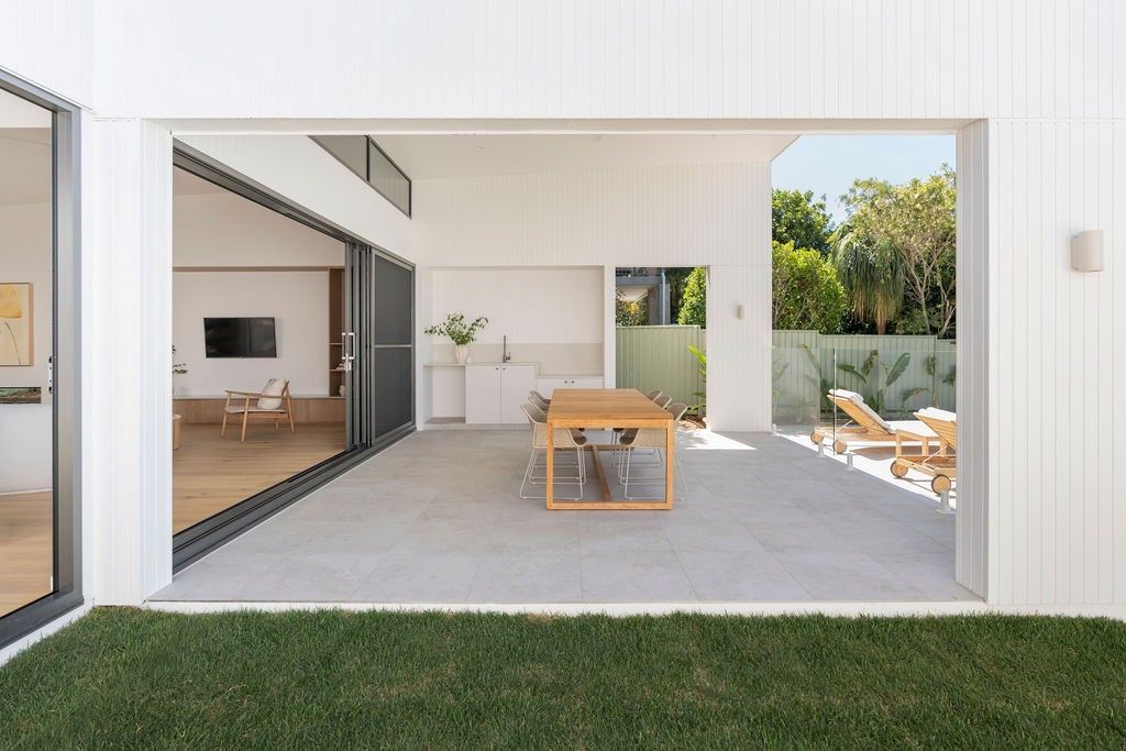 Outdoor patio with wooden table, chairs, and sliding doors — Architectural Glass Solutions QLD in Cooroy, QLD