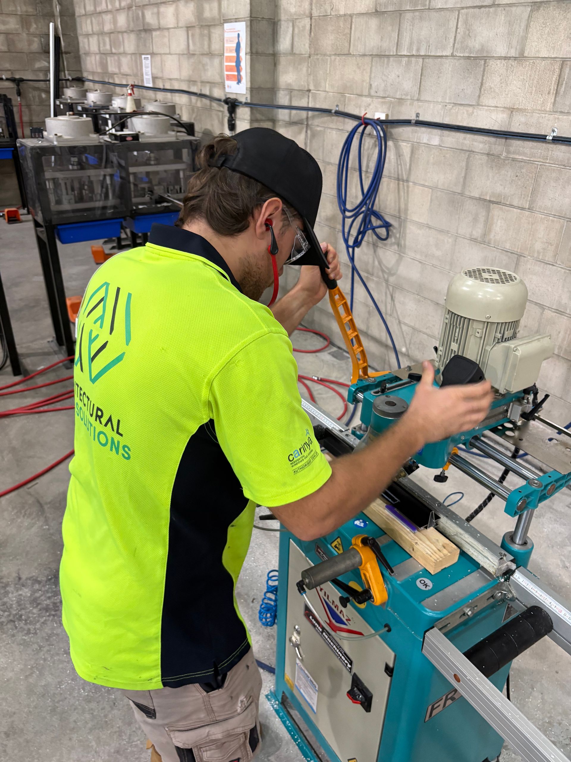 A Man is Using a Machine in a Workshop — Architectural Glass Solutions QLD in Cooroy, QLD