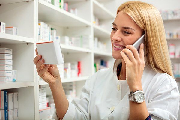 Pharmacist Calling While Holding A Medicine — New York City — Enexia Pharmacy