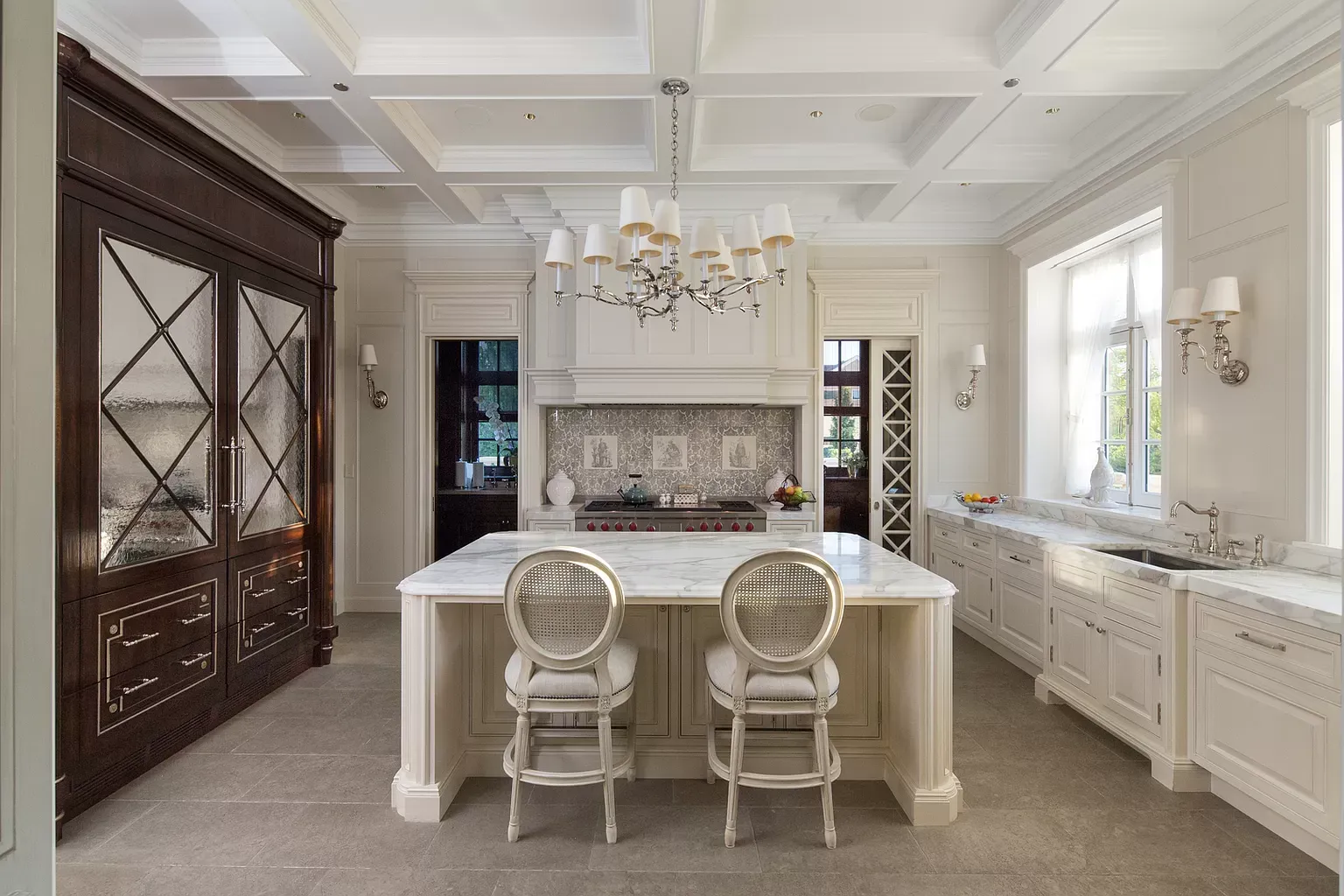 A large kitchen with a large island and two chairs.