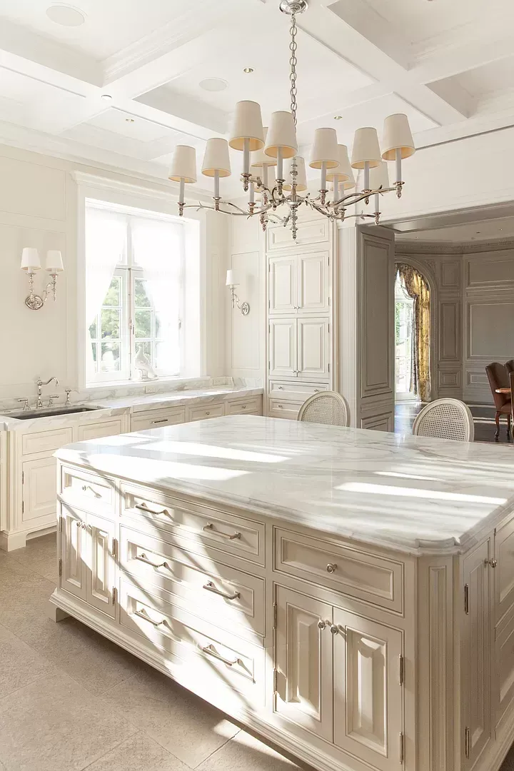 A kitchen with a large island and a chandelier hanging from the ceiling.