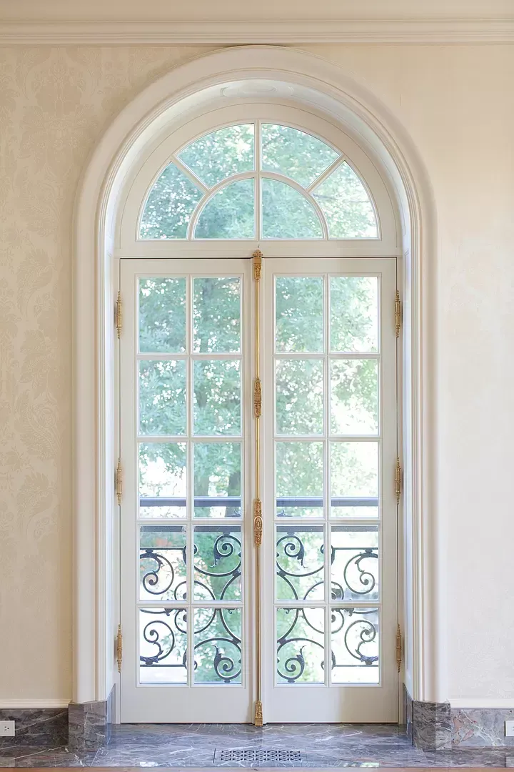 A pair of arched french doors leading to a balcony.