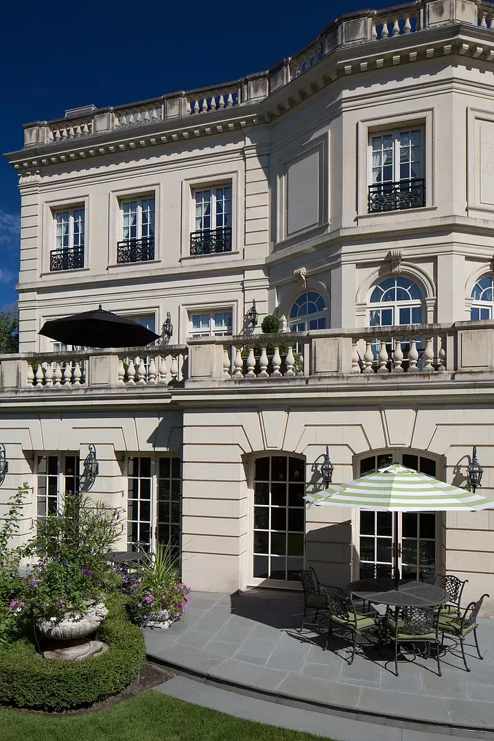 A large building with tables and chairs and umbrellas in front of it