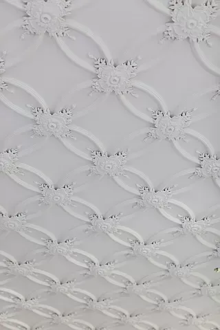A close up of a white ceiling with a pattern on it.