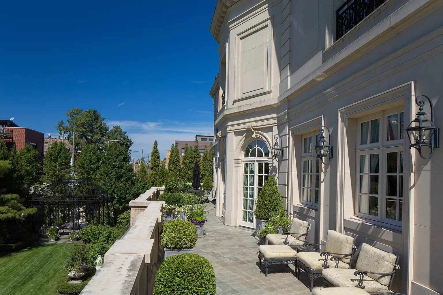 A large white building with a patio and chairs in front of it