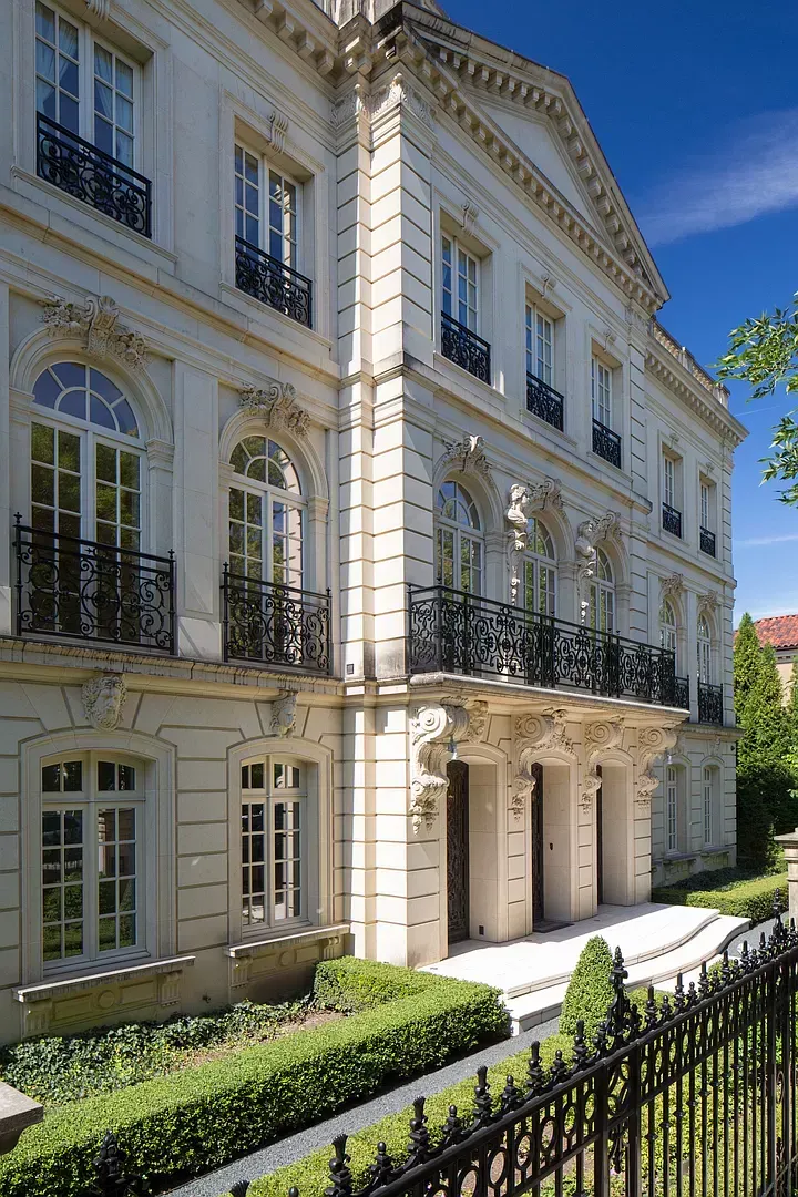 A large white building with a black fence in front of it.