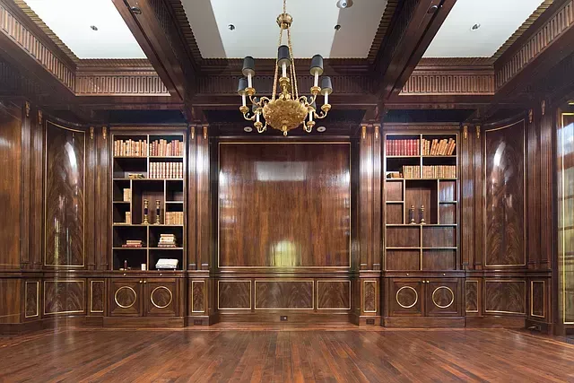 A large room with lots of bookshelves and a chandelier