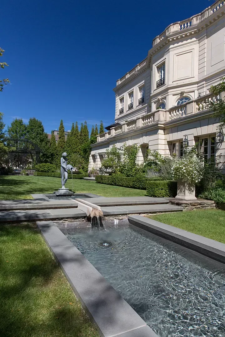 A large white building with a fountain in front of it.