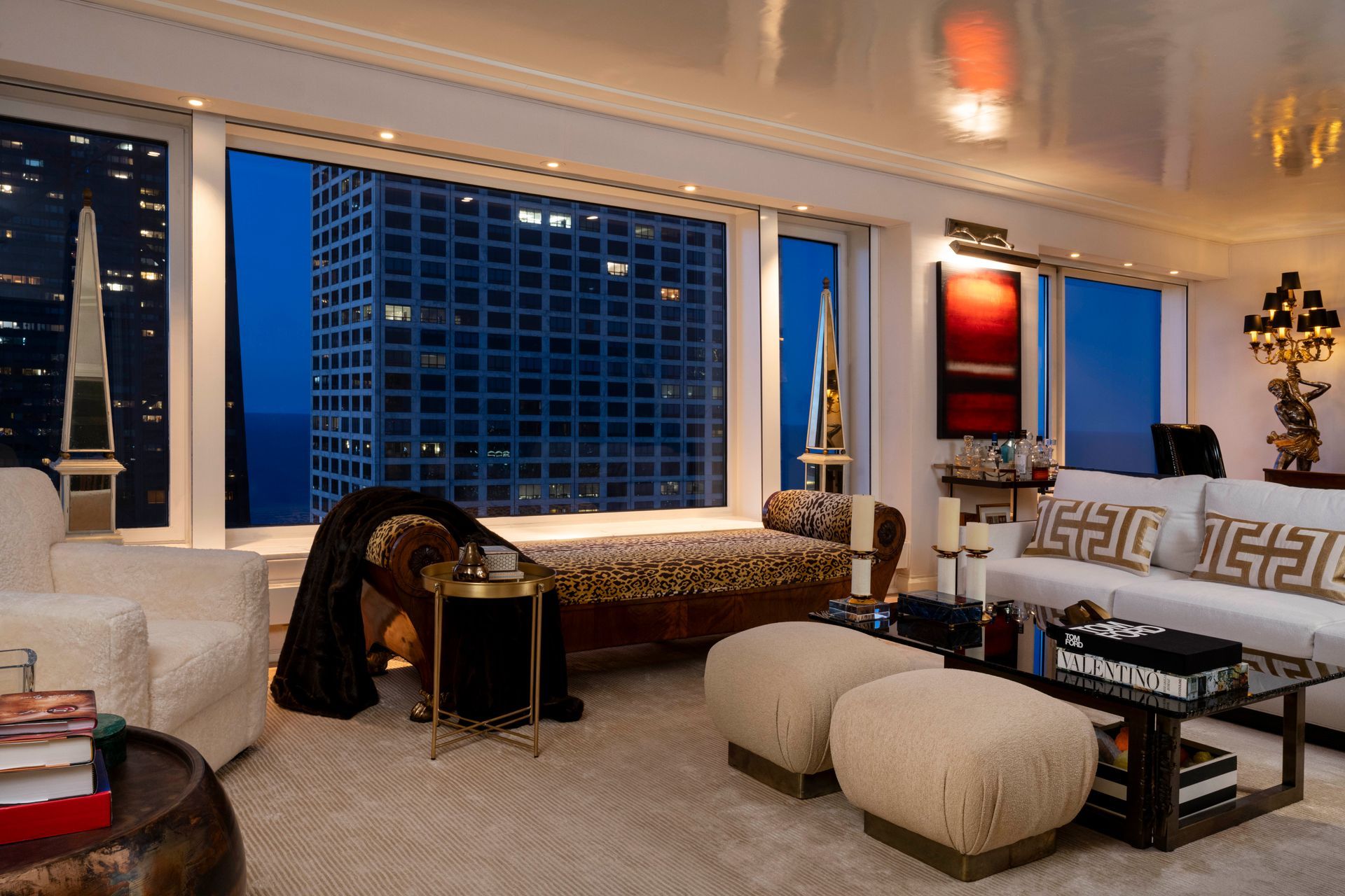 A living room with a white couch and ottomans