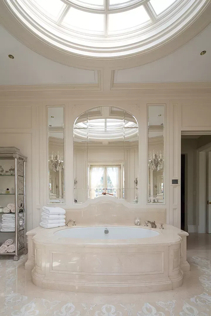A bathroom with a tub and a skylight in the ceiling.