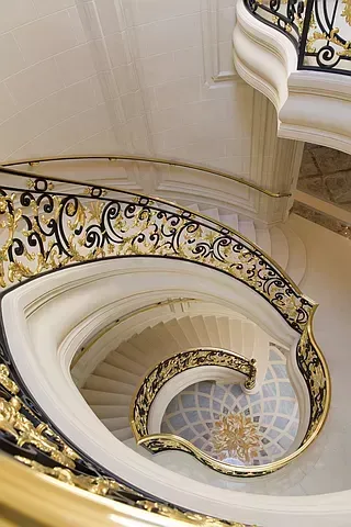 A spiral staircase with a wrought iron railing in a building