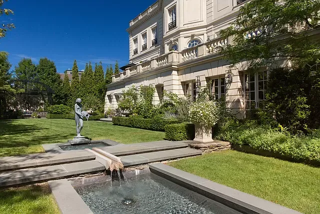 A large house with a fountain in front of it.