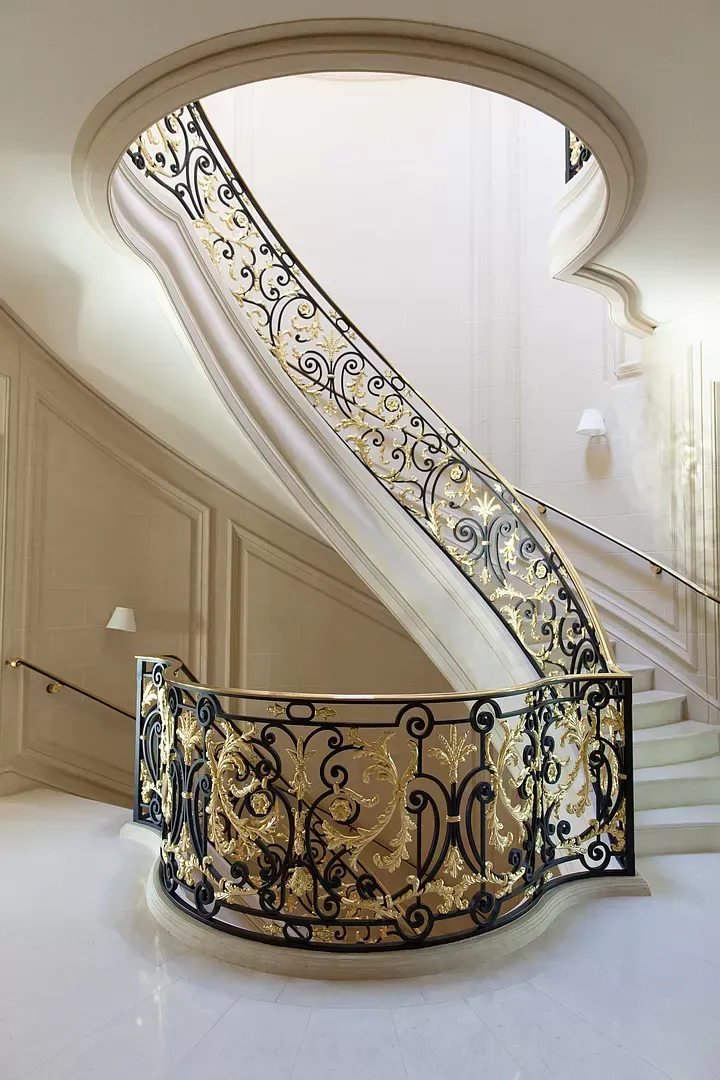 A spiral staircase with a wrought iron railing in a building
