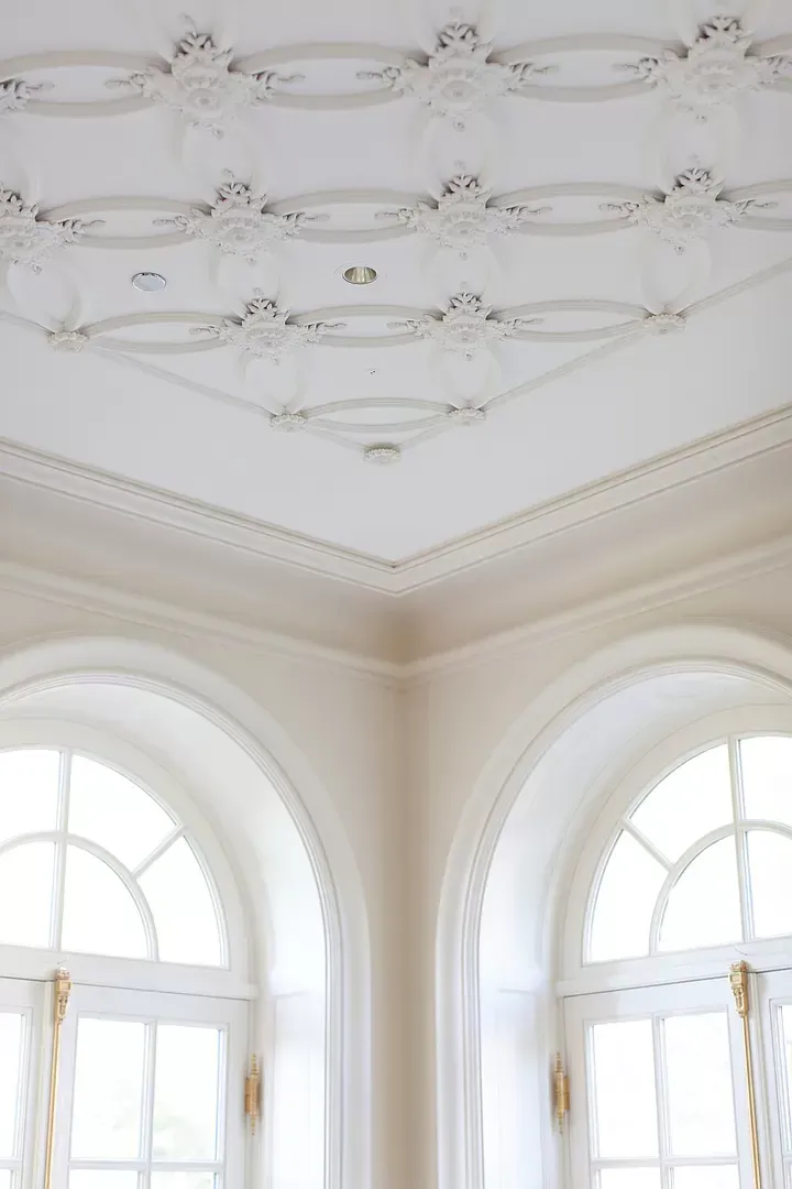 A room with arched windows and a ceiling with a pattern.