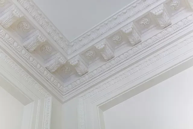 A close up of a white molding on the ceiling of a room.