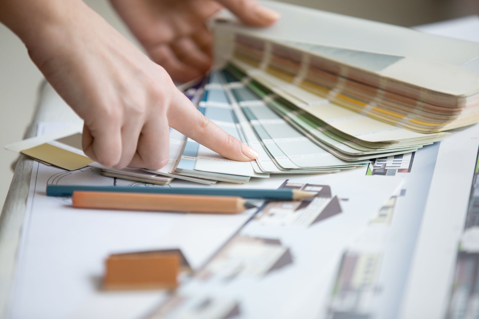 A person is pointing at a color swatch with their finger.