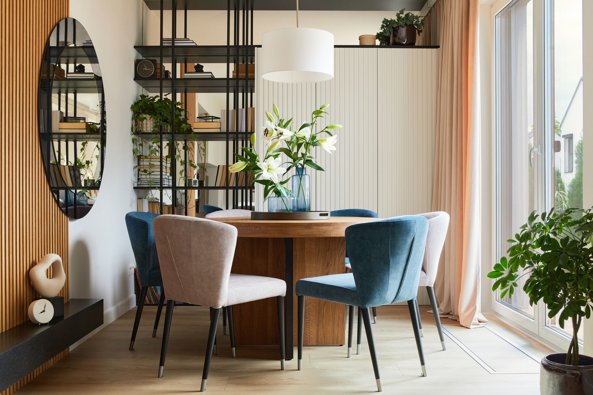 A dining room with a table and chairs and a mirror.