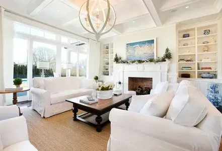 A living room with white furniture and a fireplace.