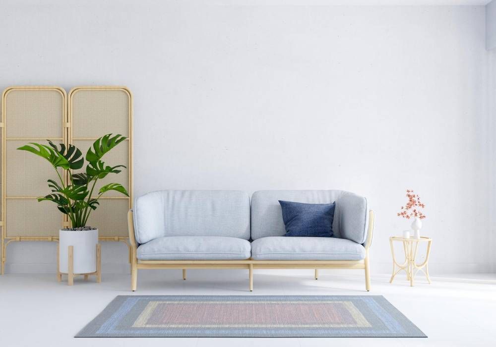 A living room with a couch , rug , and plant.