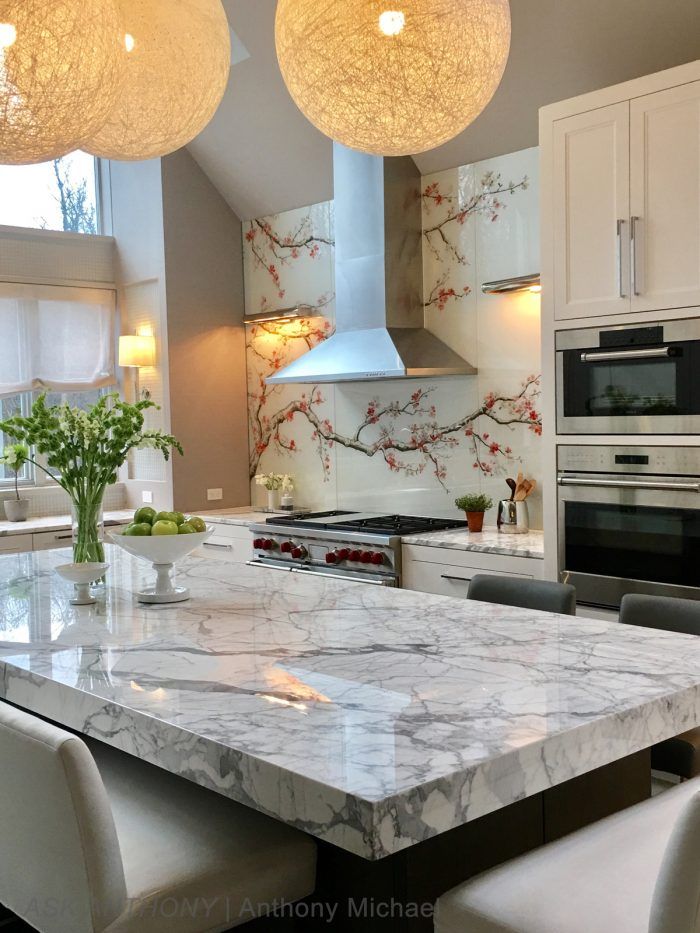 A kitchen with a marble counter top and stainless steel appliances