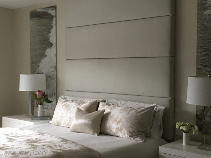 A bedroom with a bed , nightstands , lamps and a painting on the wall.