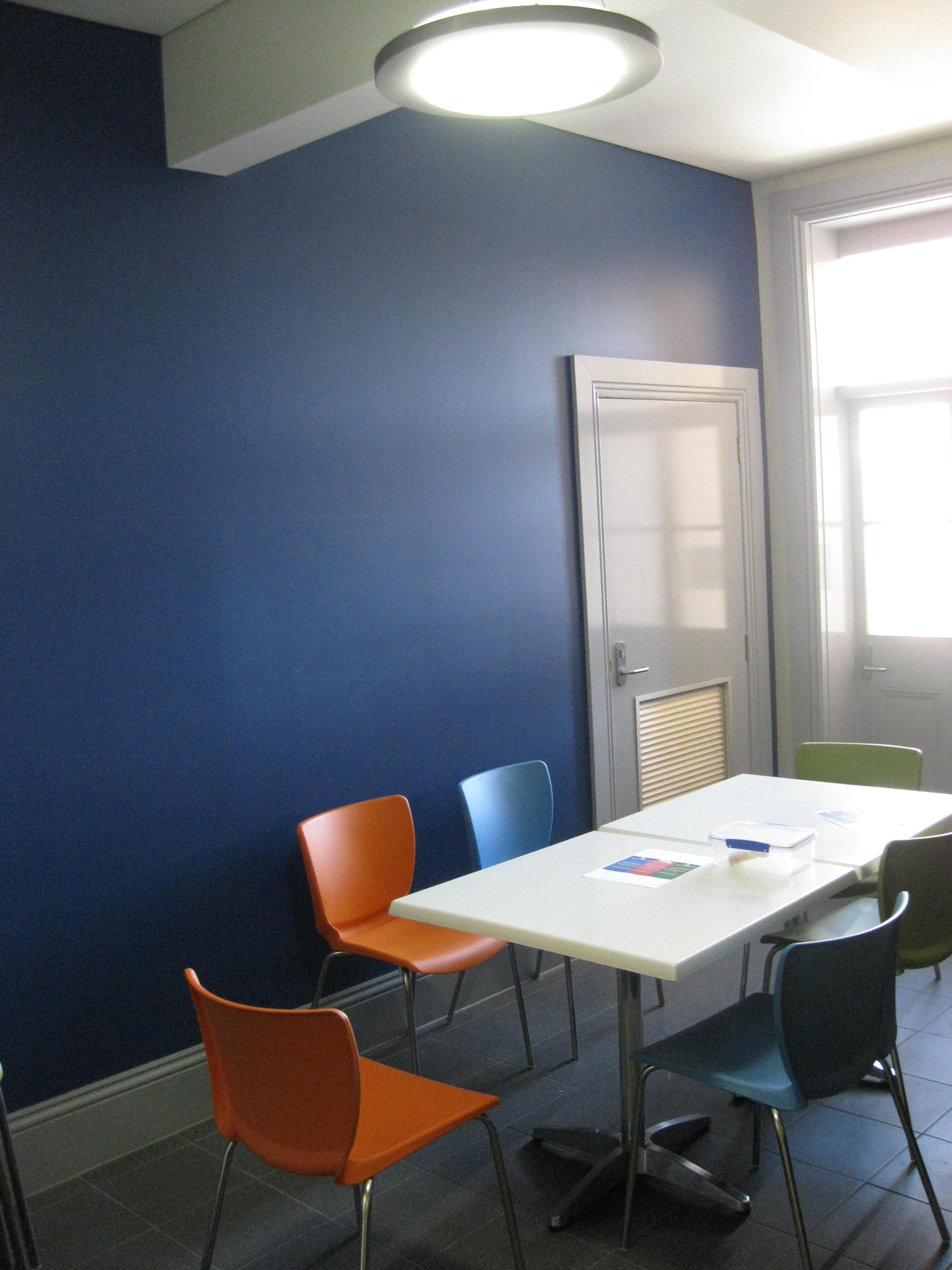 a room with a table and chairs and a painted blue wall