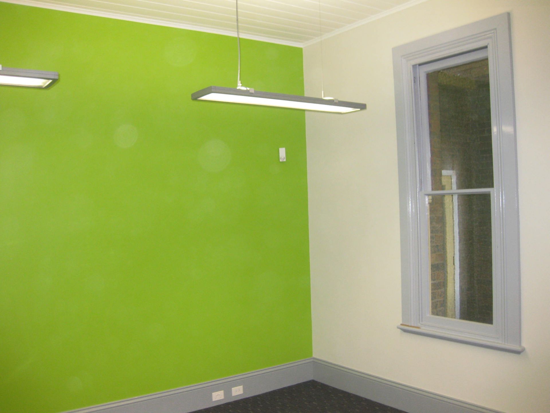 room with bright green feature wall at the Catholic Cathedral Precinct in Armidale