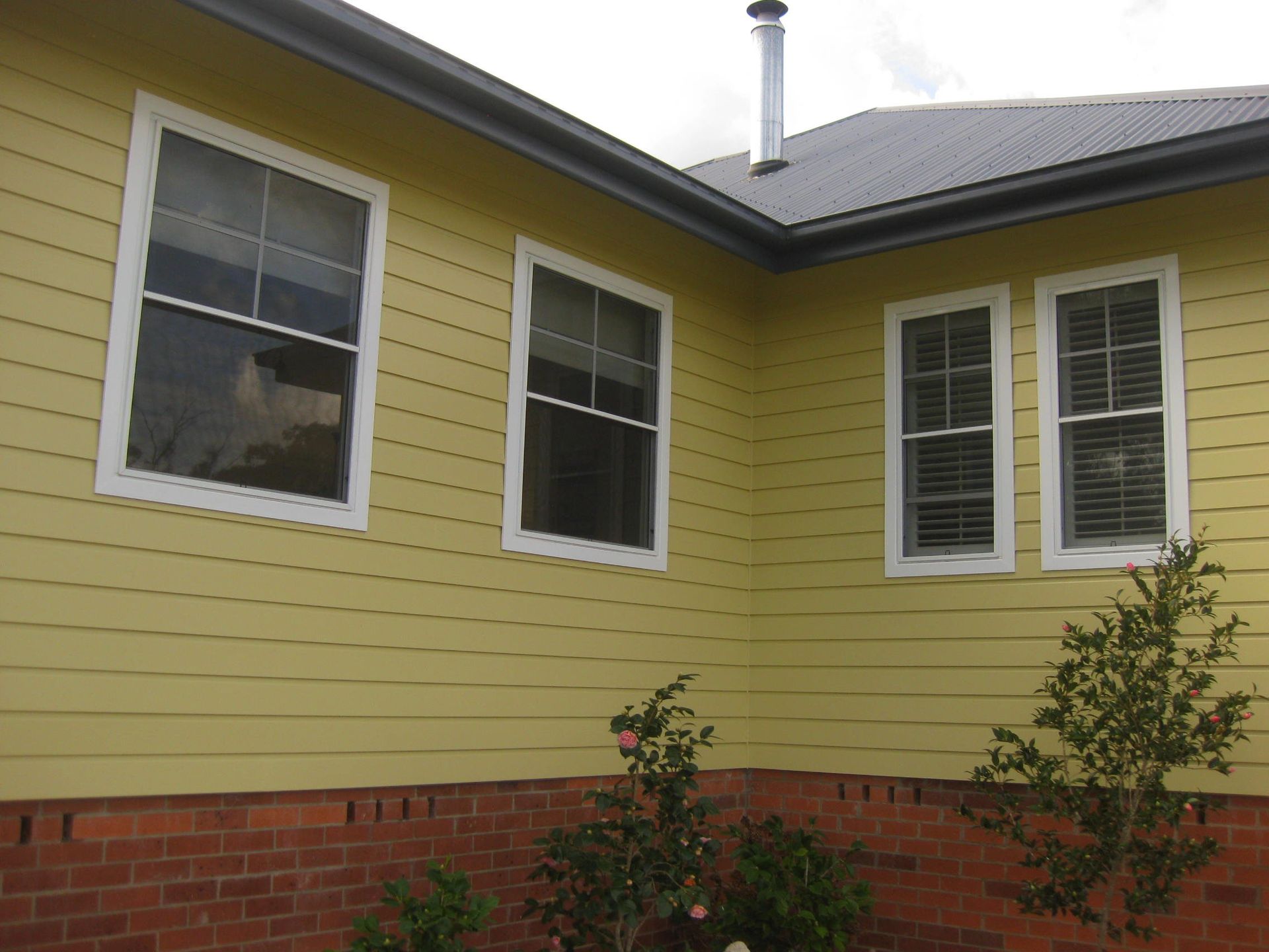 corner of home with yellow walls and four windows with white trims