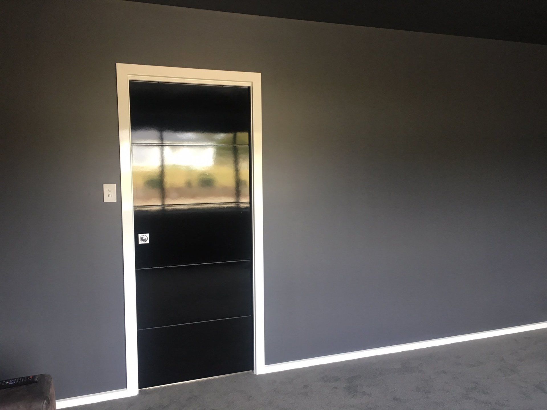 fresh painted grey interior wall with a glossy black door