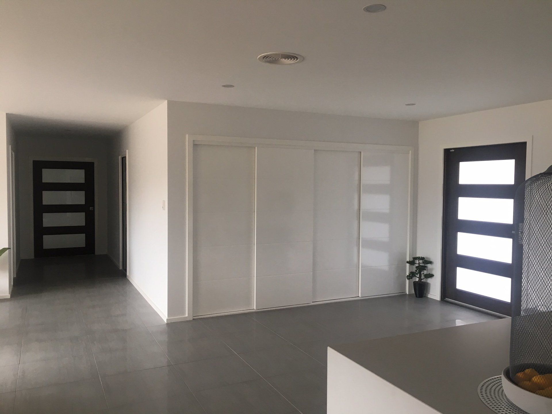 entry area with 3 glossy white doors and freshly painted white walls