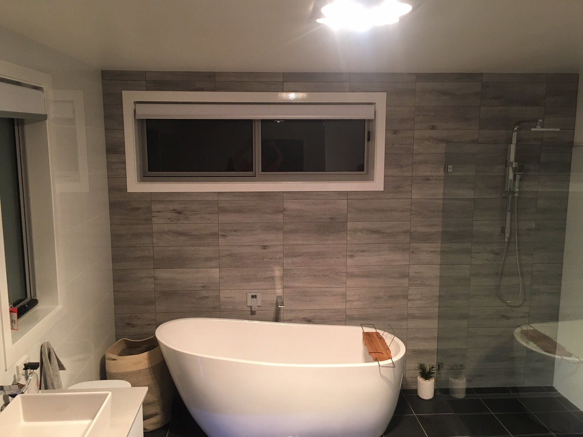 a bathroom with a tub , sink , shower and window .