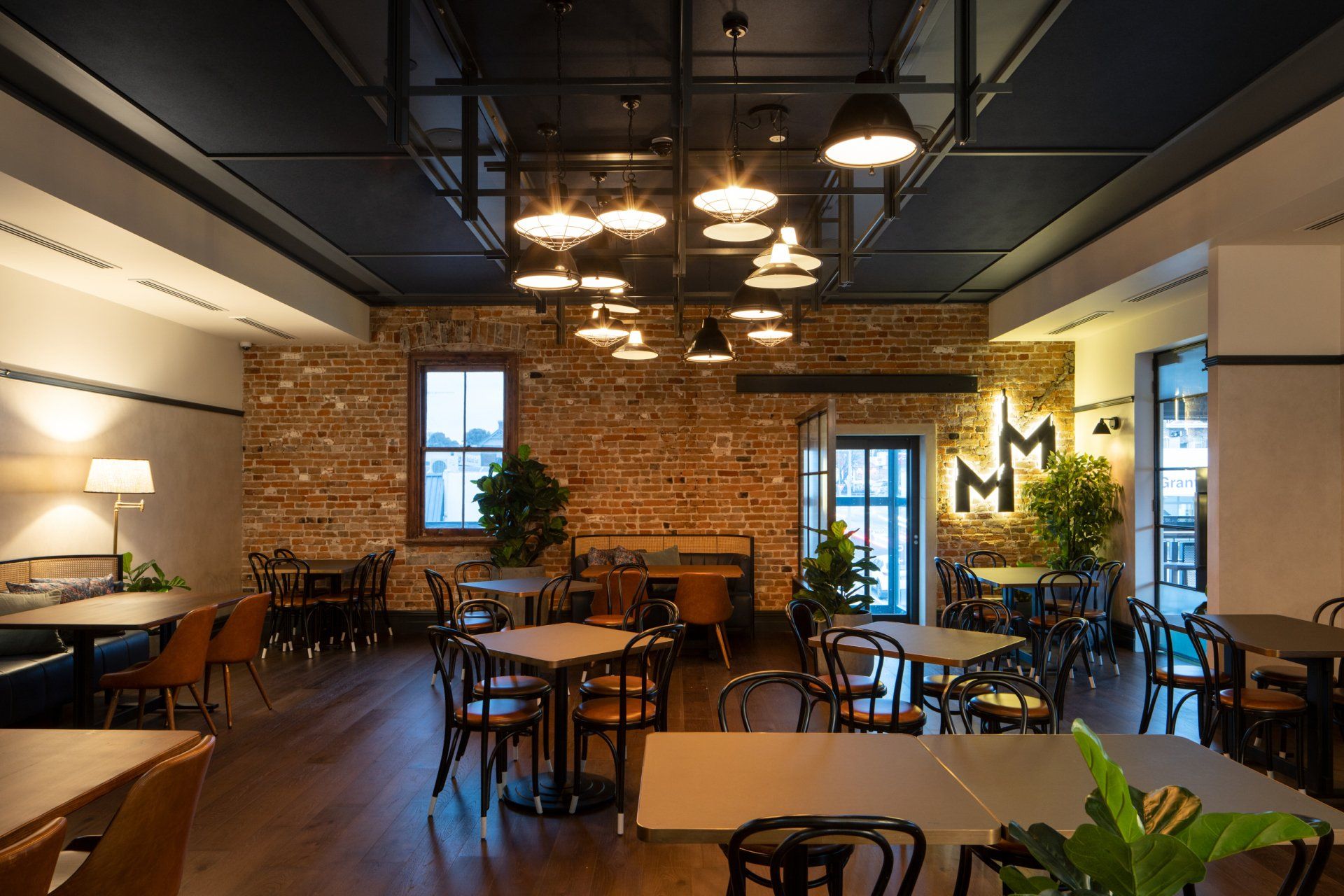 a restaurant dining room at whitebull hotel with tables and chairs and a brick wall .