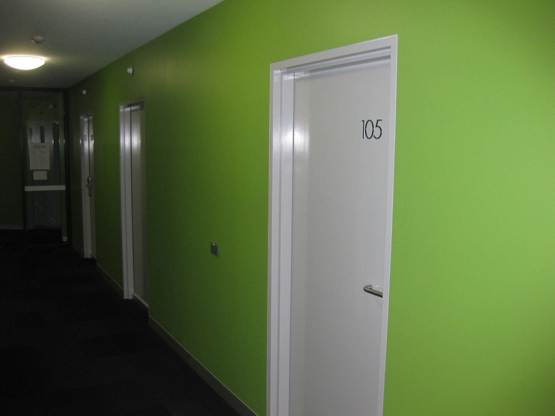 door to dorm room with green feature wall