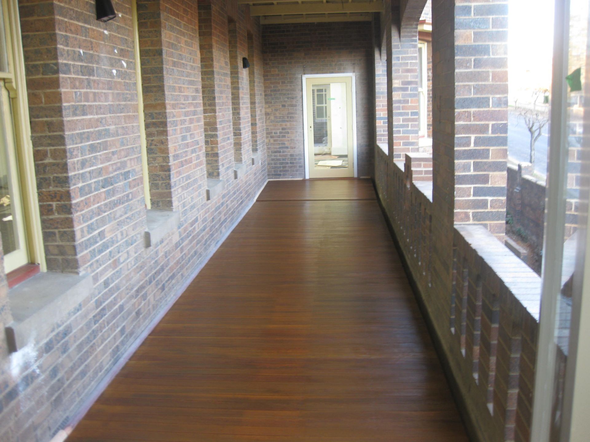a long hallway with brick walls and wooden floors at the catholic cathedral precinct
