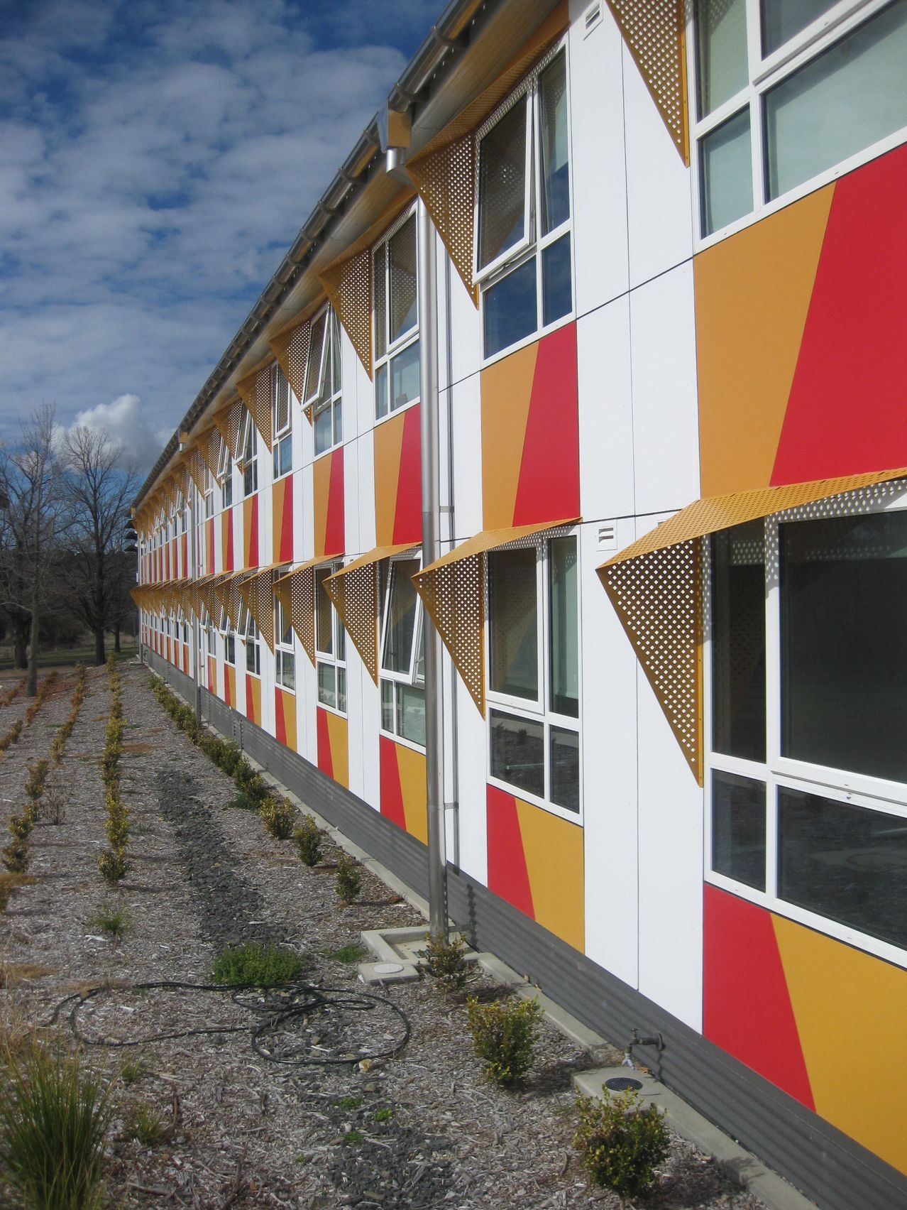 exterior wall of wright college university of new england with red yellow and white painted stripes on it