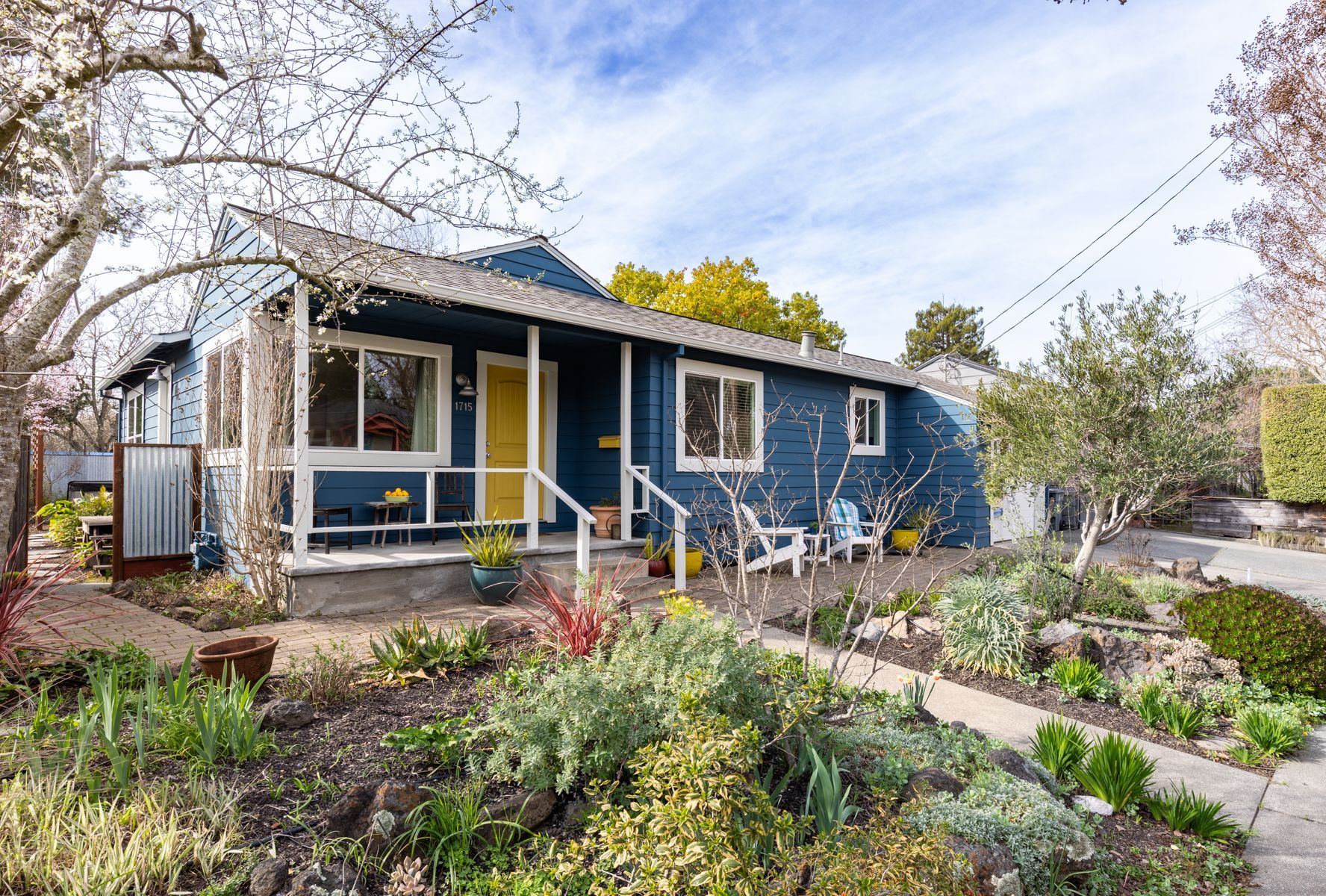 A blue house with a yellow door and a porch