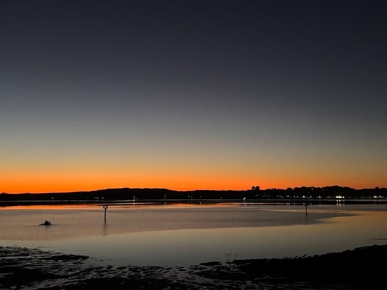 A body of water with a sunset in the background