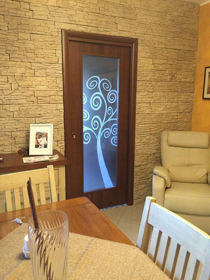 Un soggiorno con una porta a vetri con un albero sopra