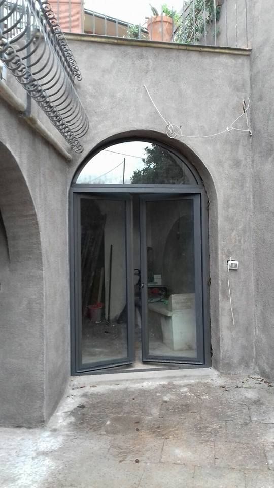 Un edificio con un grande arco e una porta scorrevole in vetro.