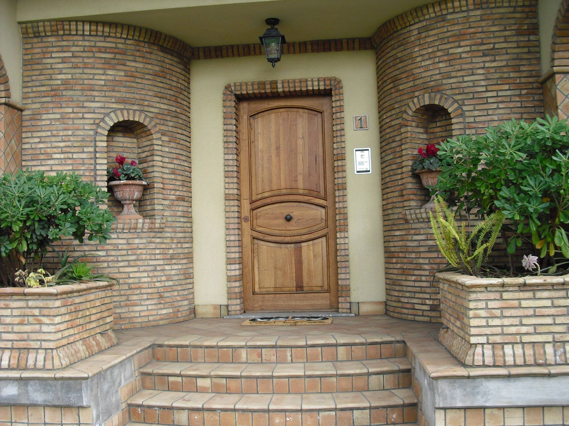 Un edificio in mattoni con una porta e scale in legno
