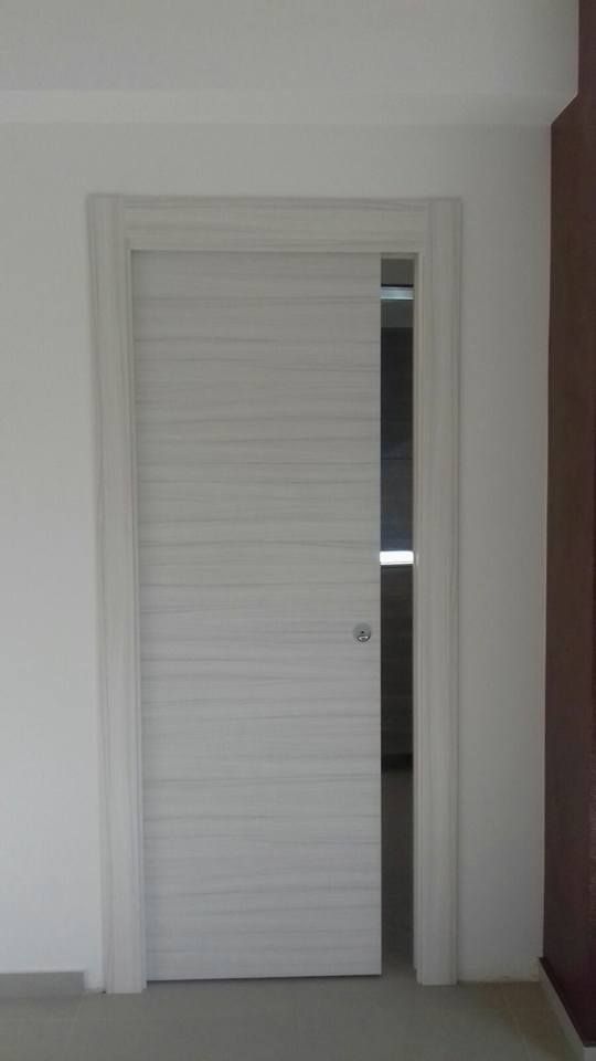 Una porta scorrevole bianca è aperta in una stanza.