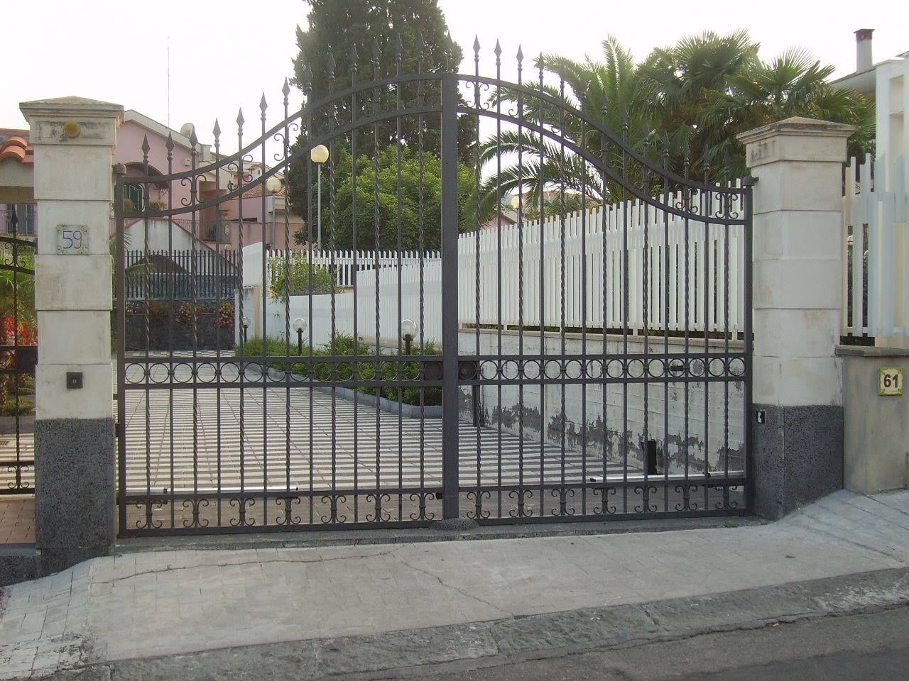 Un cancello in ferro battuto è aperto su un vialetto