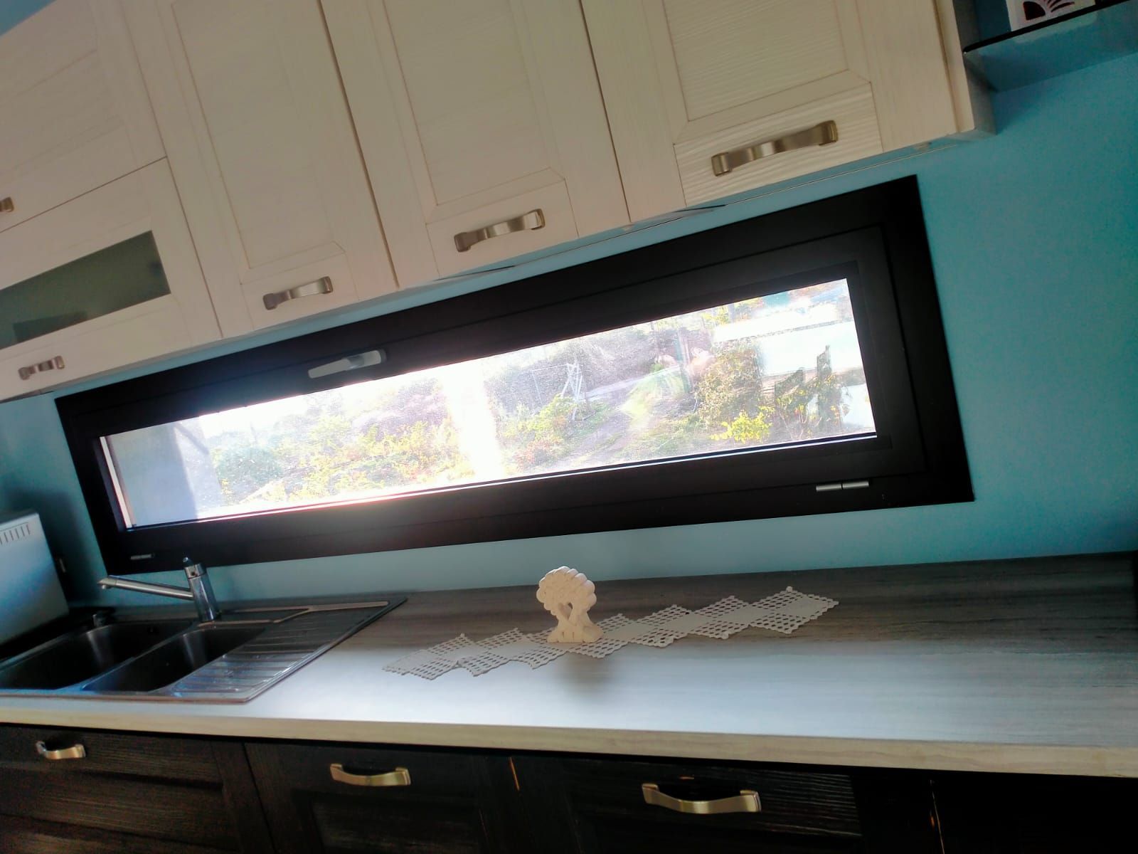 Una cucina con una grande finestra e un lavandino