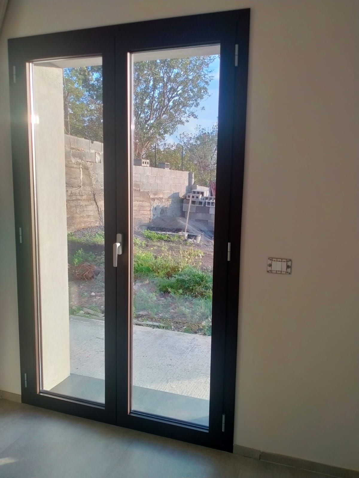 Una stanza con una porta scorrevole in vetro che conduce a un patio.