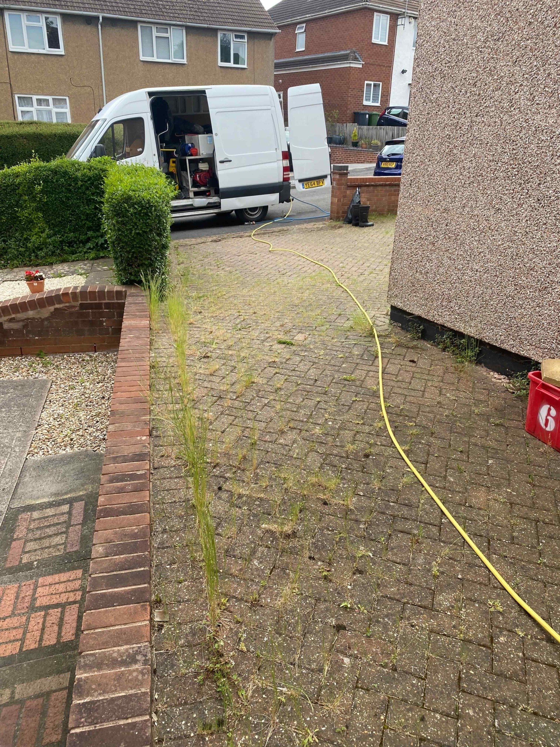 block paved driveway with weeds growing in warwickshire