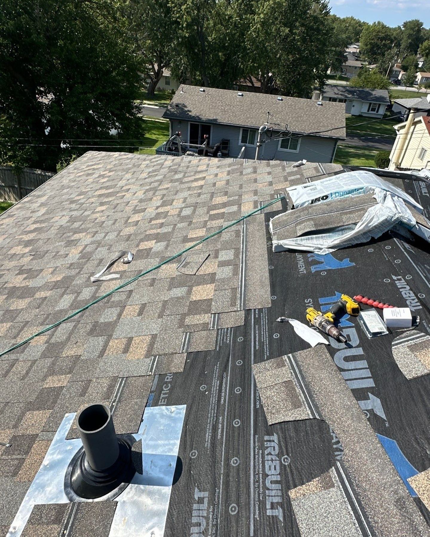 The roof of a house is being repaired with a hose attached to it.