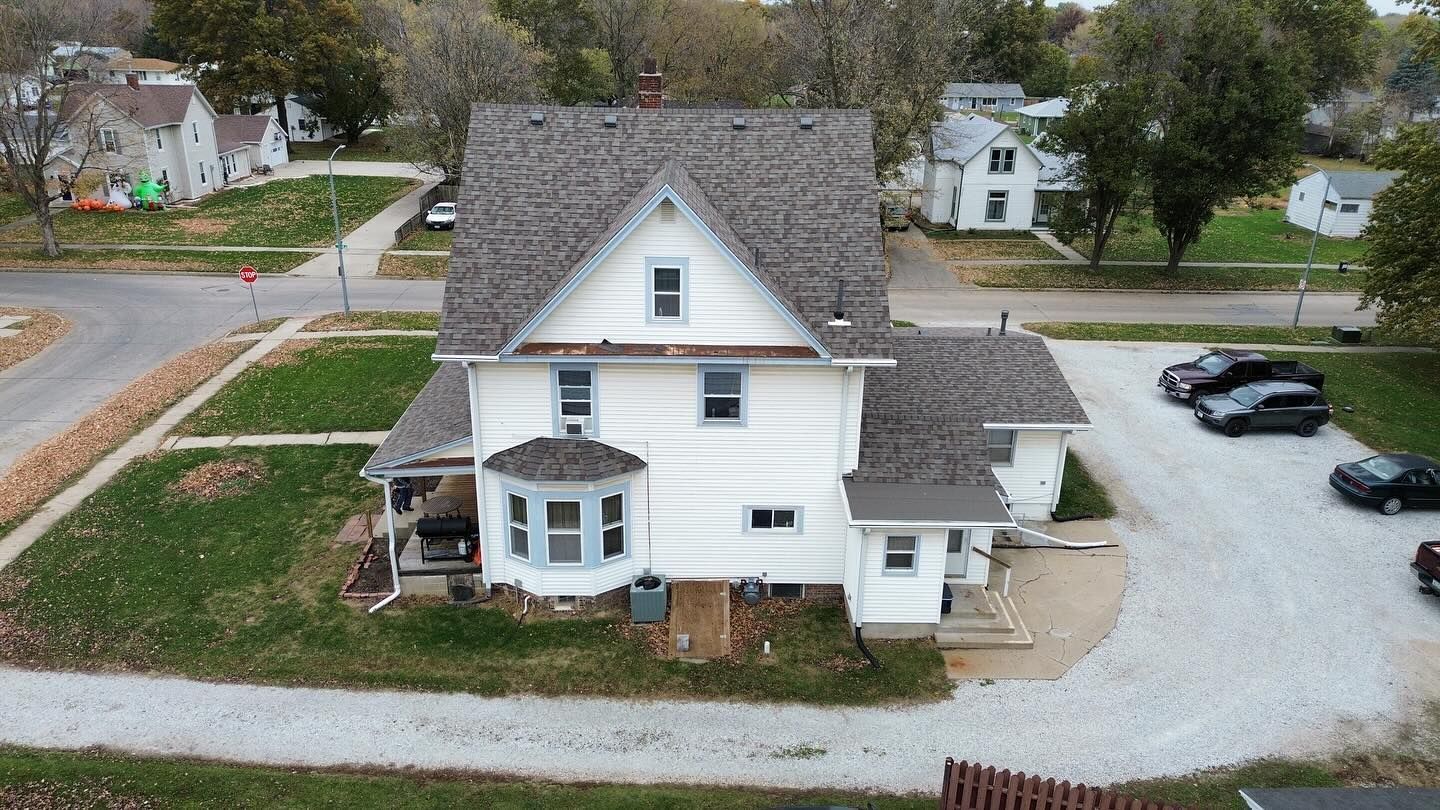An aerial view of a large white house in a small town.