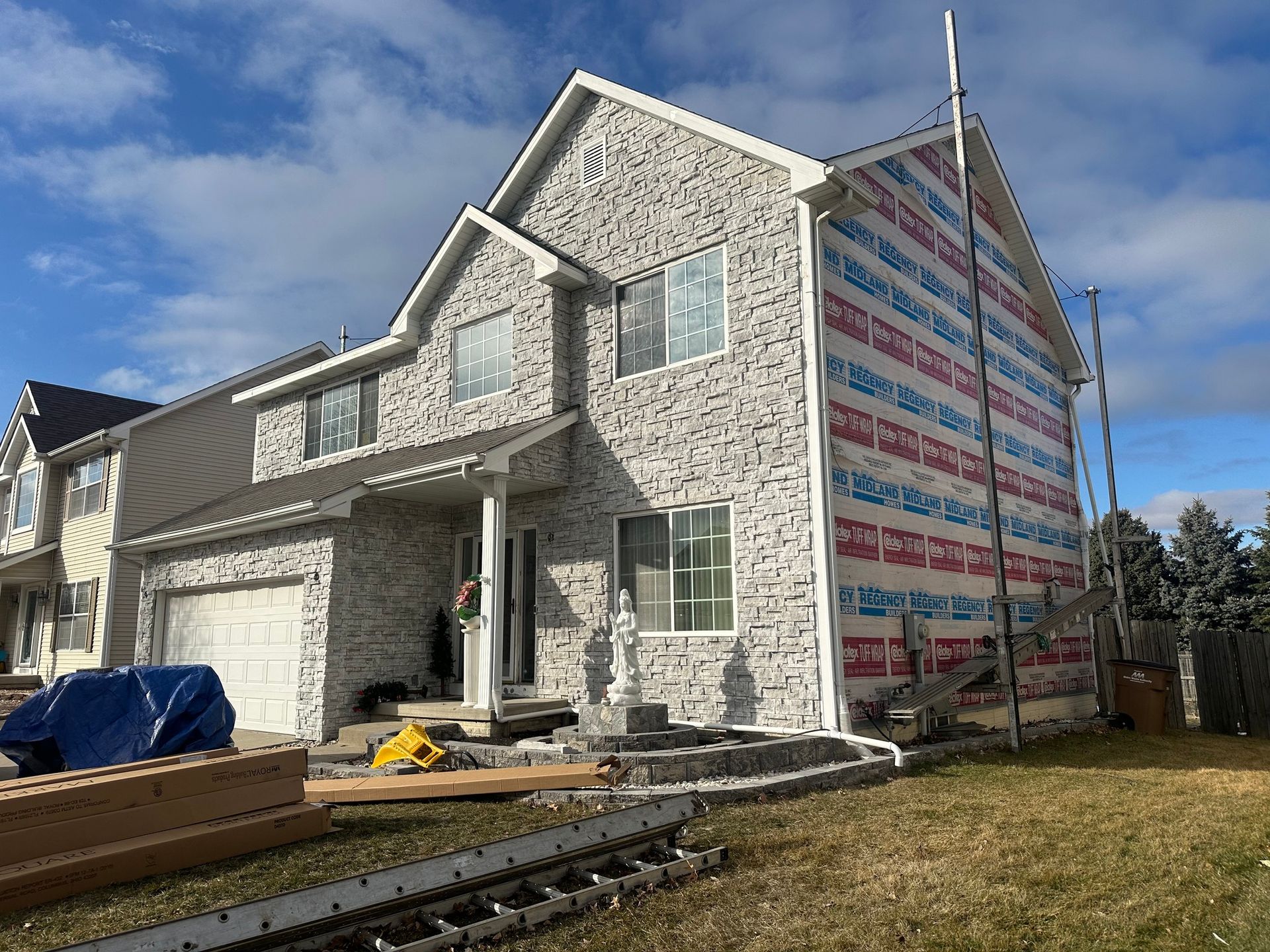 A large white brick house with a lot of windows is being built.